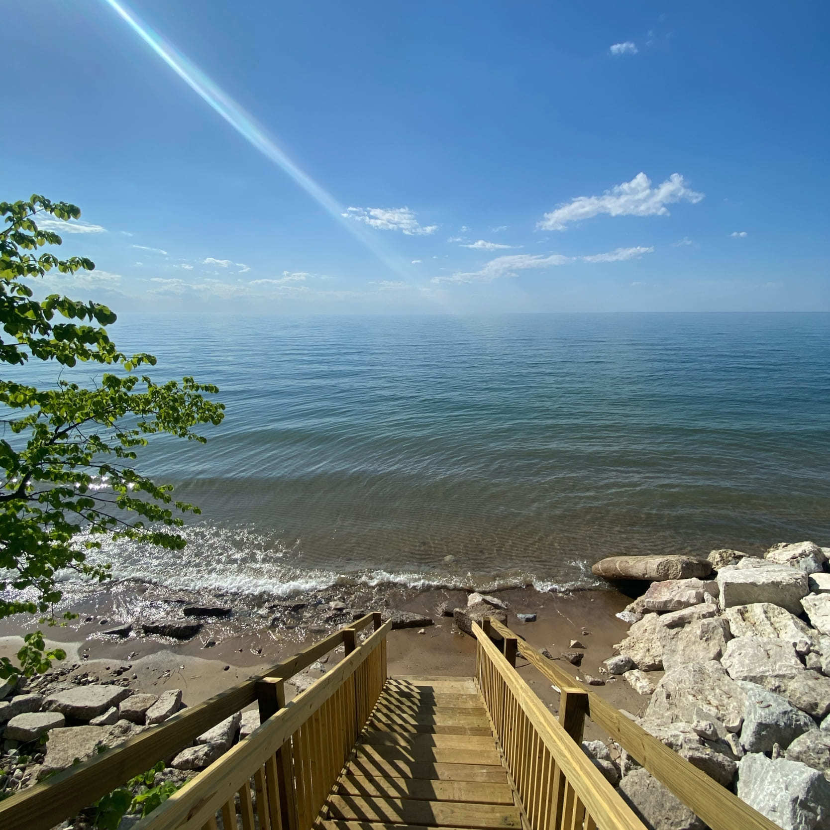 A wooden set of stairs heading down to a beach by the lake in Ontario